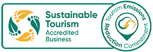 Logo for Sustainable Tourism Accredited Business, featuring green and yellow leaves and footprints.