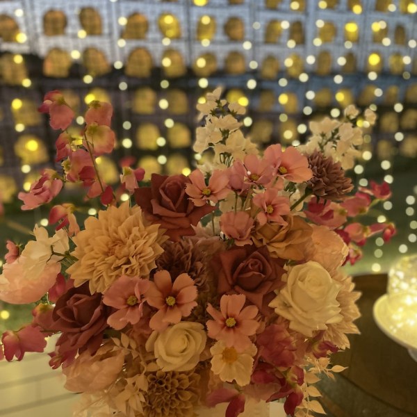 Bouquet of pink and white flowers with blurred lights in the background.